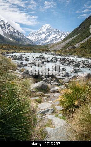 Ritratto del fiume ghiacciaio che conduce alla montagna in background fatto in giornata di sole. Girato ad Aoraki / Mt Cook National Park, Nuova Zelanda Foto Stock