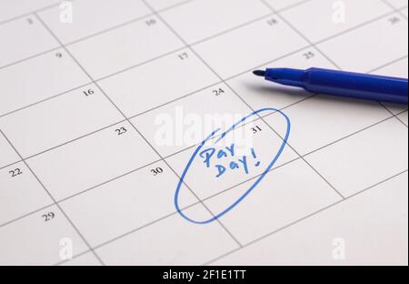 Pay Day, parole in blu scritte sul calendario. Concetto di stipendio o di libro paga. Foto Stock