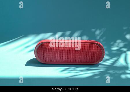 Altoparlante rosso Mini bluetooth isolato su sfondo blu con ombre. Spazio di copia. Foto Stock