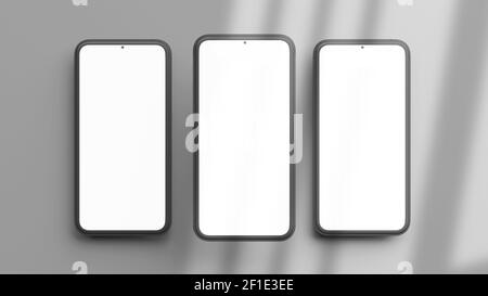 Tre modelli di telefoni verticali isolati su uno sfondo grigio in modalità flat lay e rendering 3D. Modello realistico di telaio cellulare e display vuoto conce Foto Stock