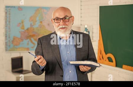 Insegnante di vecchia generazione della scuola. Docente esperto. Insegnante maturo buon insegnamento. Condivisione delle conoscenze. Ottenere certificazioni per programmi specifici. Insegnante di uomo intelligente senior presso la lavagna. Foto Stock