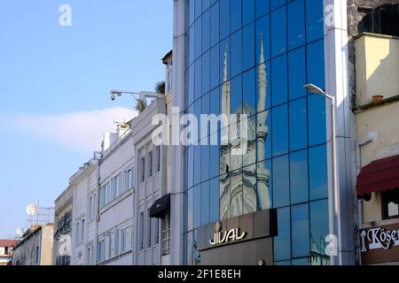 Istanbul una moschea in beyazit Way istanbul nuruosmaniye moschea. Riflesso della moschea nuruosmaniye su vetro blu e edificio moderno. Foto Stock