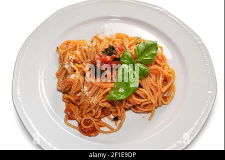 spaghetti in salsa di pomodoro con foglie di basilico nel piatto isolato su bianco, vista dall'alto, primo piano Foto Stock