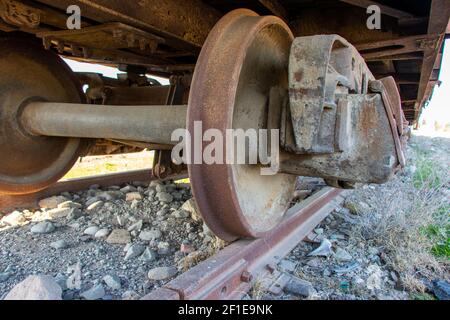 Foto di primo piano delle ruote per auto su rotaia industriale. Vecchie ruote del treno arrugginite. Sistema treno ruote su cingoli. Foto Stock