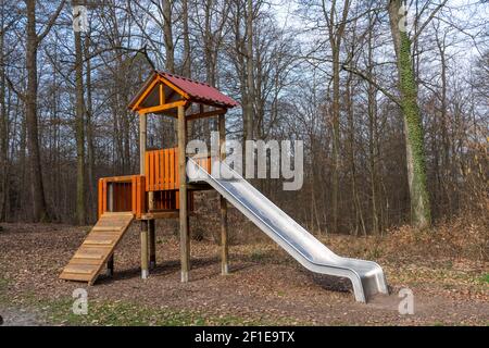 Scivolo e torre di arrampicata per i bambini in una radura in la foresta Foto Stock