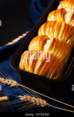 Concetto di cibo spot Focus fatto in casa lana organico morbido latte pane su sfondo nero con spazio per la copia Foto Stock