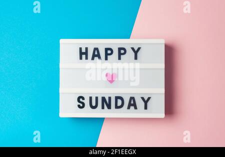 Happy Sunday - testo sul display luminoso su sfondo blu e rosa. Foto Stock