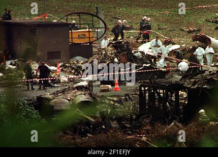 La scena Air France Concorde Crash nei pressi di Charles De Gaulle Aeroporto 2000 i resti di uno dei motori Concorde verso il basso a sinistra tra i resti di charred l'hotel vicino all'aeroporto in cui si è schiantato l'aereo dopo un incendio si sviluppò nelle ali e nei motori di L'aereo al decollo Stretcher portatori di un corpo dal relitto Foto Stock