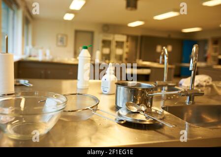 Primo piano di una lezione di cucina a scuola con cucina usata utensili Foto Stock