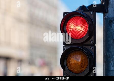 primo piano del semaforo del traffico con semaforo rosso sulla città sfocata sfondo stradale con spazio di copia Foto Stock