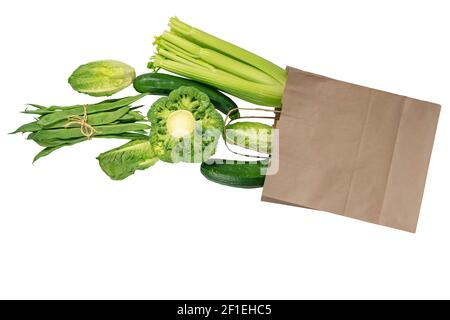 Verdure verdi che volano dalla borsa di carta Kraft isolato su bianco. Mangiare sano. Foto Stock