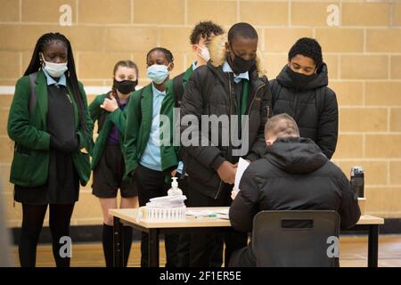 Gli alunni della Sydney Russell School, Dagenham, nella zona est di Londra, si accodano per essere testati per Covid-19 mentre gli alunni in Inghilterra tornano a scuola per la prima volta in due mesi, come parte della prima fase di alleggerimento del blocco. Data immagine: Lunedì 8 marzo 2021. Foto Stock