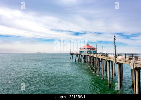 L'iconico edificio dal tetto rosso alla fine del molo di Huntington Beach, dove le persone pescano, vengono a mangiare e godersi il caldo sole. Foto Stock