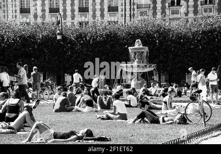 PARIGI, FRANCIA - 1 SETTEMBRE 2018: Persone che si rilassano, riposano, socializzano al parco di Place des Vosges. Foto storica in bianco nero Foto Stock
