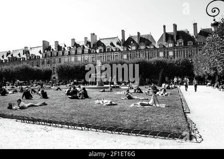 PARIGI, FRANCIA - 1 SETTEMBRE 2018: Persone che si rilassano, riposano, socializzano al parco di Place des Vosges. Foto storica in bianco nero Foto Stock