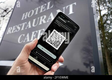 Symbolbild: Luca-App mit QR-Code auf einem smartphone vor einem Restaurant-Swild. In Kooperation mit dem Berliner Start-up nexenio Hat Rapper Smuto von den Fantastischen Vier die neue Corona-App entwickelt. ermöglicht die digitale Dokumentation von Besucherlisten sowie die Kontaktverfolgung von Infektionsketten bei privaten Treffen. Mit der smartphone-App können sich die Besucher von Gaststätten oder Kulturveranstaltungen per QR-Code ein- und ausloggen. Anonym verschlüsselte Datenübermittlung zur Kontaktnachverfolgung können damit die Gesundheitsämter entlasten. Foto vom 08.03.2021 Foto Stock