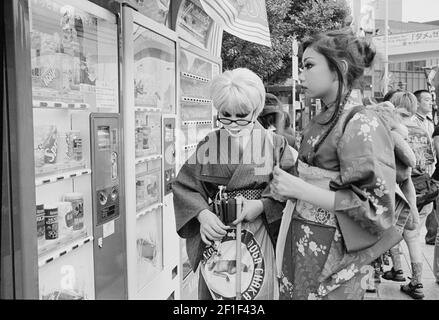 Ragazze di fronte a distributori automatici vestiti in elegante Yukata.Japanese adolescenti vestiti in Tokyo Street fashion, Yoyogi Park, Harajuku, Giappone Foto Stock