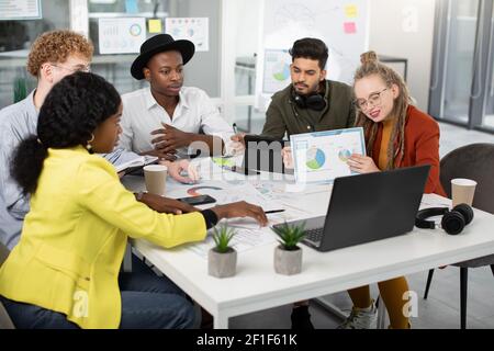 Team multiculturale che ha una videoconferenza su un laptop Foto Stock