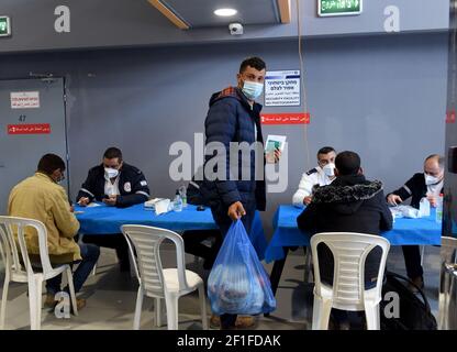 Lamed Hei Checkpoint, Palestina, 8 marzo 2021. I lavoratori palestinesi si registrano presso il Magen David Adom di Israele per ricevere la prima dose del vaccino moderna COVID-19 al Lamed Hei Checkpoint tra Gush Etzion e Beit Shemesh, lunedì 8 marzo 2021. Israele ha avviato una campagna di due settimane per vaccinare circa 100,000 lavoratori palestinesi della Cisgiordania che detengono permessi per lavorare in Israele e negli insediamenti ebraici Foto Stock