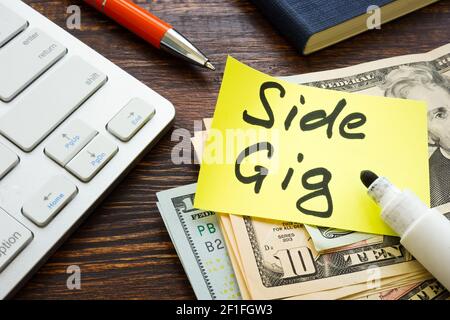 Soldi dal concerto laterale e dalla tastiera sulla scrivania. Foto Stock