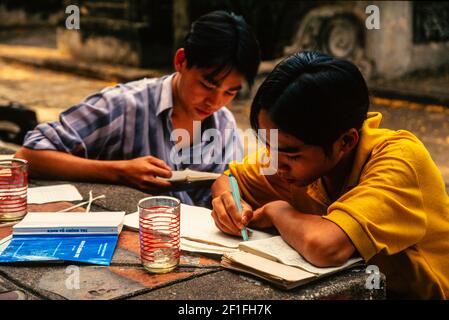 Studenti al lavoro ad un tavolo del parco, ho Chi Minh City, ottobre 1995 Foto Stock