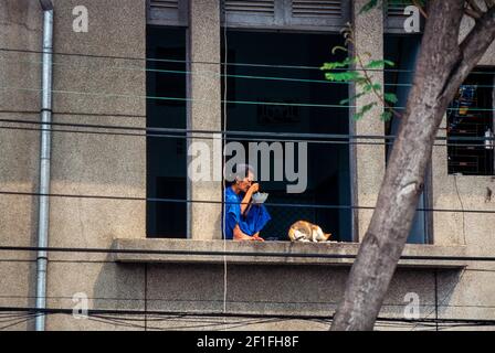 Un womam e il suo gatto che fa colazione, ho Chi Minh City, ottobre 1995g Foto Stock
