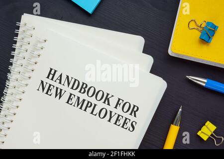 Pila di manuale per i nuovi dipendenti sulla scrivania. Foto Stock