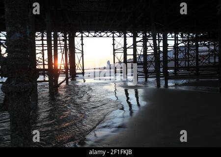 Tramonto invernale da sotto il molo di Hastings, East Sussex, Regno Unito Foto Stock