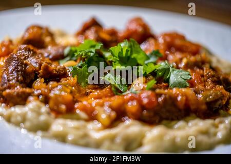 Purea di melanzane con yogurt servito con carne macinata stagionata Foto Stock