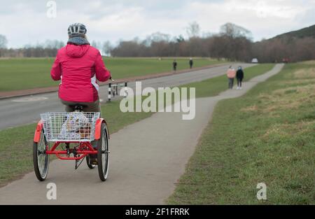Edimburgo, Scozia, Regno Unito. 8 Marzo 2021. Una donna su un tricilce sulla pista ciclabile di Arthur's Seat, Holyrood Park, Edimburgo, 8 marzo 2021. Credit: Gayle McIntyre/Alamy Live News Foto Stock