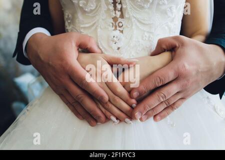 Abbracci. Braccio da uomo intorno alla vita della donna. Amanti delle braccia. L'uomo abbraccia la ragazza Foto Stock