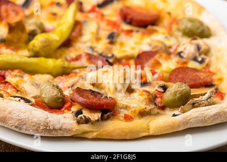 Primo piano di una pizza su un piatto Foto Stock
