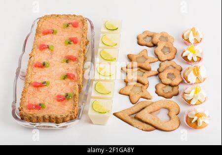 Vari deliziosi dessert a tavola. Su sfondo bianco. Foto Stock