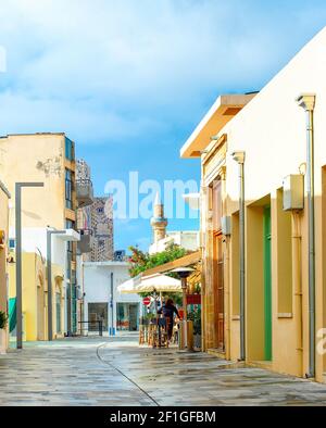 Strada turistica centrale con ristoranti e negozi, moschea in background, Paphos, Cipro Foto Stock