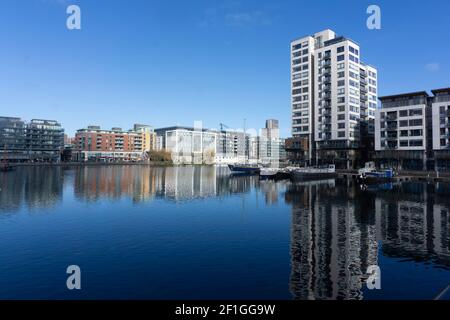 Grand Canal Docks a Dublino, Irlanda con la Millennium Apartment Tower sulla destra e le case galleggianti sul canale ormeggiate sulla banchina. Foto Stock