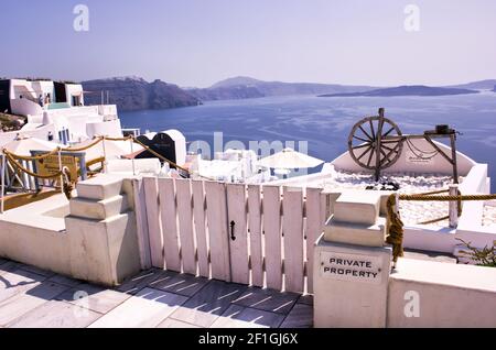 Santorini, Grecia - 11 settembre 2017: Tradizionale ruota girevole tenuta dietro un cancello di legno come decorazione a Oia, Thira, Isole Cicladi, greco Isla Foto Stock