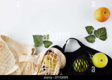 Borsa per la spesa in mesh con mele verdi su sfondo bianco. Concetto di shopping senza sprechi. Foto Stock