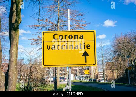 Segnale di direzione che indica la strada per un luogo di vaccinazione corona (in olandese). Foto Stock