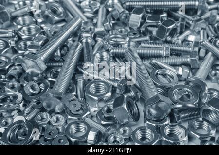 Chromeplated bulloni e dadi su sfondo bianco Foto Stock