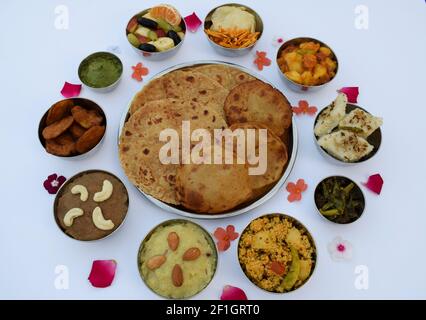 Piatti tradizionali indiani Farali serviti in thali e bocce con molti oggetti per upawas upawas o vrat ka khana. Decorato con petali di fiori per il digiuno Foto Stock