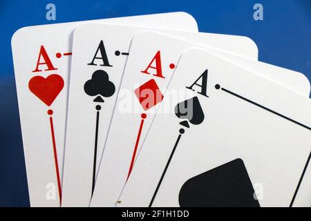 Un primo piano della mano di un uomo che tiene quattro assi sullo sfondo di un tavolo da poker Foto Stock