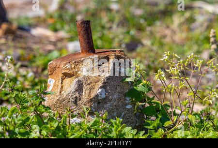 Un robusto blocco di cemento con un tubo di acciaio arrugginito che si stacca da esso, è tutto ciò che rimane di qualunque esso mantenuto insieme prima, come segno di lento ma al posto Foto Stock