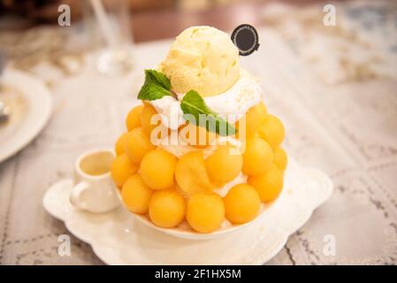 Dessert Bingsu, frutta bingsu cantaloupe con menù di crema di latte mangiare fresco dolce ghiacciato servito sul tavolo cibo coreano Foto Stock