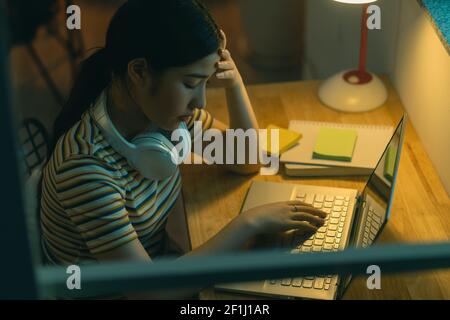 Donna asiatica stanca che cerca di portare a termine il lavoro di notte Foto Stock