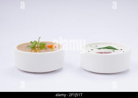 Chutney bianco di cocco e sambar, disposti in una tavola bianca che viene posta su sfondo bianco testurizzato. Foto Stock