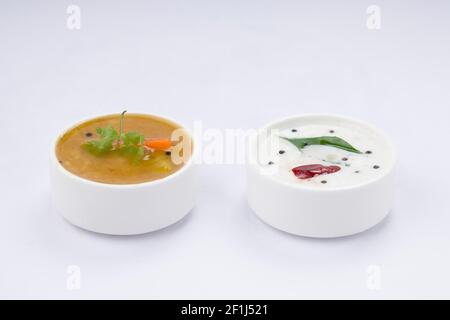 Chutney bianco di cocco e sambar, disposti in una tavola bianca che viene posta su sfondo bianco testurizzato. Foto Stock