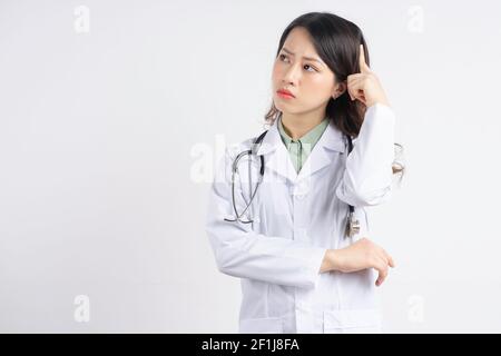 Ritratto di una dottoressa asiatica che graffia la testa pensiero Foto Stock