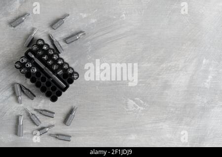 Punte per cacciaviti per vari standard in un pratico contenitore su fondo in cemento grigio. Messa a fuoco selettiva. Foto Stock