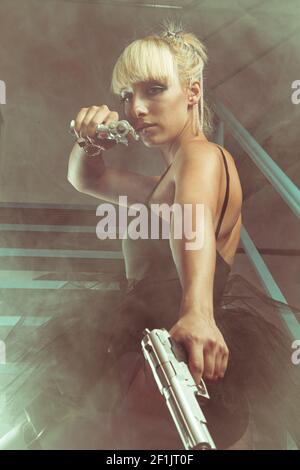 Cosplay, ragazza bionda con pistole in una fabbrica abbandonata. cosplayer, azione e pericolosa donna Foto Stock