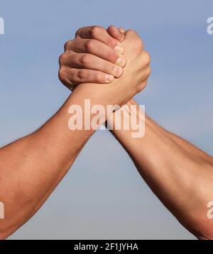 Confronto tra rivalità della mano e forza della sfida. Mano dell'uomo. Due uomini braccio wrestling. Lottando con le braccia. Chiudi. Amichevole stretta di mano, amici saluto Foto Stock